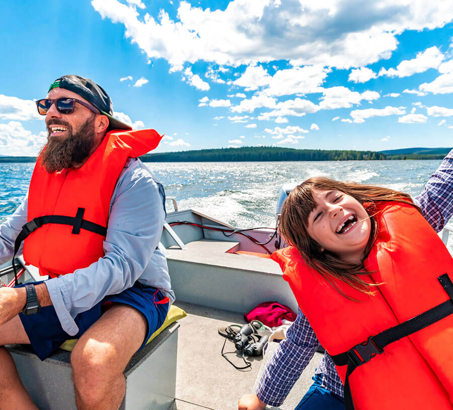 A father and child sitting on a boat financed with a Boat Loan from Red Canoe